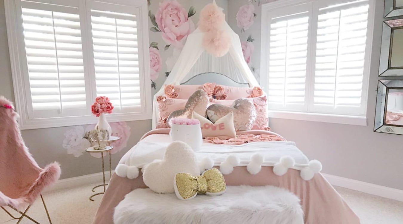  Frilly bedroom with pink bedspread and white interior shutters